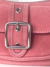 Load image into Gallery viewer, Close-up of a dusty pink suede handbag featuring a large silver-tone square buckle, metal eyelets, and white contrast stitching.