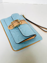Load image into Gallery viewer, A light blue embossed leather wallet or card holder with tan leather trim and a gold-tone buckle detail, shown on a plain white background.