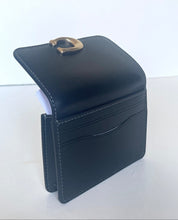 Load image into Gallery viewer, A black leather card holder wallet with a gold-tone metal D-ring closure, shown open on a plain white background.
