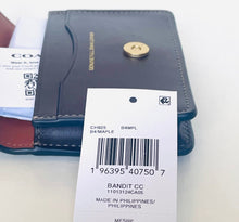 Load image into Gallery viewer, A Coach Bandit CC card holder wallet in dark navy blue leather with a gold snap button, shown with its original retail tag and a white Coach card on a light background.