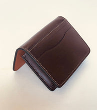 Load image into Gallery viewer, A dark brown leather bi-fold wallet with visible contrast stitching, standing open on a plain off-white surface.