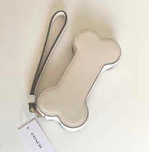 Load image into Gallery viewer, Beige Coach keychain with a strap on a light beige background
