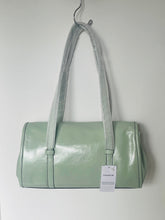 Load image into Gallery viewer, Light green handbag with a tag on a white background