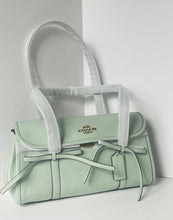 Load image into Gallery viewer, Light green handbag with a visible brand logo on a white background