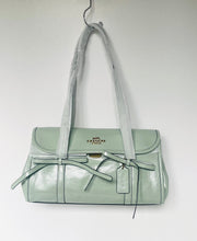 Load image into Gallery viewer, Light green handbag with a visible brand logo on a white background