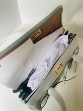 Load image into Gallery viewer, Open handbag with white interior and gold hardware on a light background