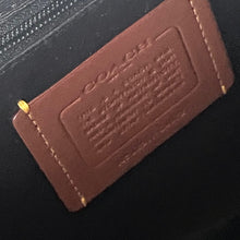 Load image into Gallery viewer, Close-up of a Coach label on a product with a black background