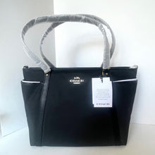 Load image into Gallery viewer, Black Coach handbag with a white tag on a white background