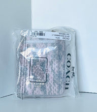 Load image into Gallery viewer, A Coach knit scarf in a clear plastic bag with a white barcode label and black COACH branding, photographed against a light gray background.