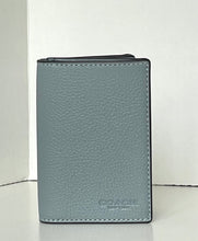 Load image into Gallery viewer, A Coach slim leather wallet in a muted blue-gray color, standing upright against a white background.