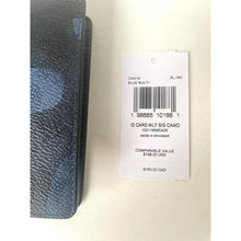 Load image into Gallery viewer, Denim wallet with a tag displaying product details on a light background