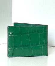 Load image into Gallery viewer, A green alligator-textured leather bifold wallet standing upright on a white surface against a white background.