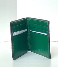 Load image into Gallery viewer, An open green leather bi-fold wallet with card slots and a small embossed Coach logo on the interior, photographed against a plain light background.