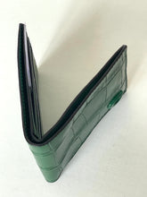 Load image into Gallery viewer, A green crocodile-embossed leather wallet shown open, displaying its interior card slots and exterior texture, set against a plain off-white background.