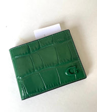 Load image into Gallery viewer, A green crocodile-embossed leather bifold wallet with a glossy finish and a green 'G' logo on the front, shown on a light beige background with a white card partially visible.