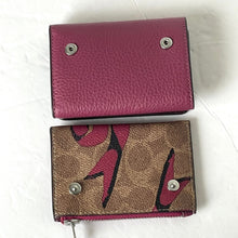 Load image into Gallery viewer, Two wallets, one pink and one with a floral pattern, on a white surface.
