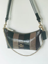 Load image into Gallery viewer, A Coach hobo shoulder bag with vertical striped panels in black, brown, and taupe, featuring a gold-tone chain strap and a black leather brand tag.