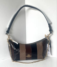 Load image into Gallery viewer, A Coach crescent shoulder bag with a glossy black and brown striped design, featuring a gold-tone logo on the front and a gold chain strap, set against a white background.