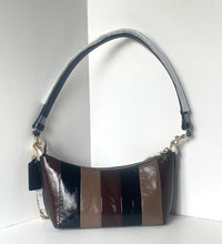 Load image into Gallery viewer, A small crescent-shaped shoulder bag with vertical stripes in glossy brown, tan, and black, featuring a black shoulder strap with a silver chain link accent.