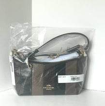 Load image into Gallery viewer, A Coach handbag in dark brown textured leather, still sealed in its clear plastic packaging with a white price tag and brand label visible.