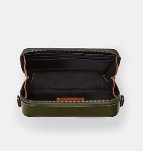 Green leather wallet with orange interior on a white background