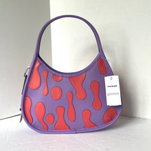 Load image into Gallery viewer, Purple handbag with red pattern and Coach tag on a white background