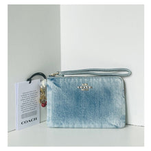 Load image into Gallery viewer, Blue denim Coach wallet with a card on a light gray background