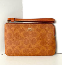 Load image into Gallery viewer, Brown Coach wristlet on a white background