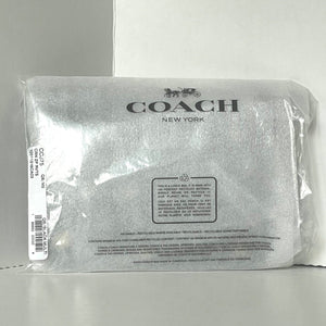 Coach New York pouch in clear packaging on a gray background