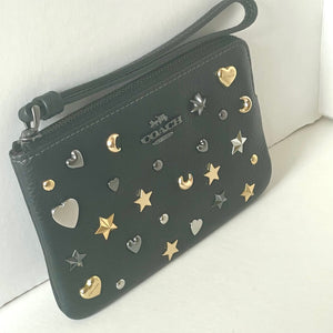 Coach wallet with star and heart embellishments on a white background
