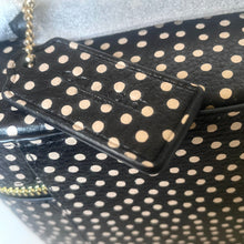 Load image into Gallery viewer, Black handbag with white polka dots and gold chain strap on a light gray background