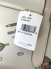 Load image into Gallery viewer, A close-up of a white pebbled leather tote bag with a colorful cartoon print, featuring a white paper price tag with a barcode and handwritten price.