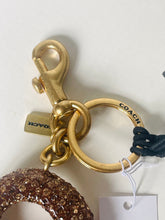 Load image into Gallery viewer, Gold Coach keychain with a tag on a white background