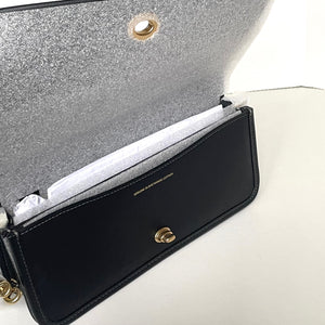 Black handbag with gold hardware on a white background