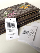 Load image into Gallery viewer, Coach wallet with floral design and price tag on a light gray background