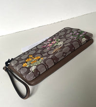 Load image into Gallery viewer, Floral-patterned wallet with brand logo on a light gray surface