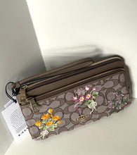 Load image into Gallery viewer, Floral-patterned wallet with a Coach logo on a white surface