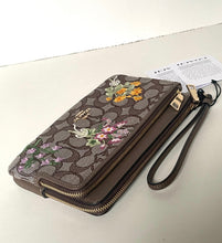 Load image into Gallery viewer, Floral embroidered wristlet on a light surface