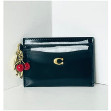Load image into Gallery viewer, Black cardholder with gold charm and red accents on a white background