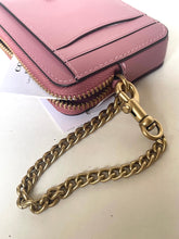 Load image into Gallery viewer, A close-up of a pink leather wallet or card holder with gold-tone hardware, including a prominent gold chain strap attached by a clasp, resting on a light surface.