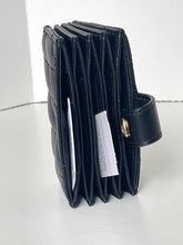Load image into Gallery viewer, A black leather accordion-style card holder wallet with a side strap and gold-tone button, standing upright on a light gray surface against a white background.