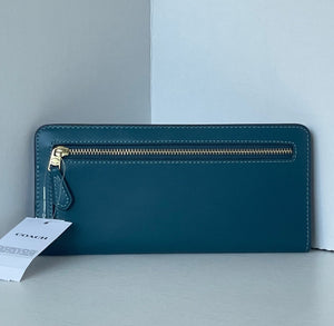 Teal wallet with gold zipper on a light gray background