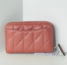 Load image into Gallery viewer, A quilted zip-around wallet in a dusty rose pink color, featuring diagonal stitching and a small green and red striped zipper pull, shown with its paper tag attached against a plain white background.