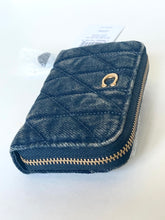 Load image into Gallery viewer, A dark blue quilted denim zip-around wallet with gold-tone hardware, shown on a plain white background with its retail tag still attached.
