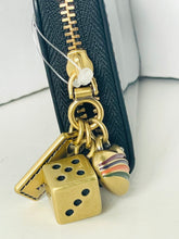 Load image into Gallery viewer, Gold dice charm with a striped shoe on a black zipper pull against a white background