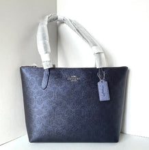 Load image into Gallery viewer, Navy blue handbag with a visible brand tag on a white background