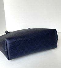Load image into Gallery viewer, A dark navy blue pebbled leather cosmetic pouch or small bag, photographed on a plain white surface against a white background.
