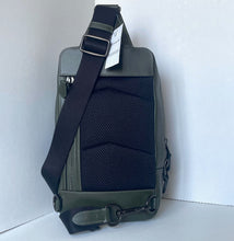 Load image into Gallery viewer, Green and black sling bag with a visible brand tag on a white background