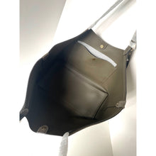 Load image into Gallery viewer, Black leather bag with a white interior on a light gray background