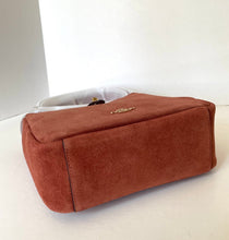 Load image into Gallery viewer, Brown suede handbag on a white surface with a white background